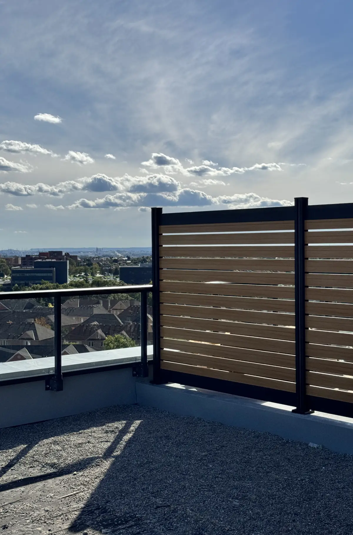 Semi-privacy wood-grain aluminum fence panels installed along a residential property in Canada
