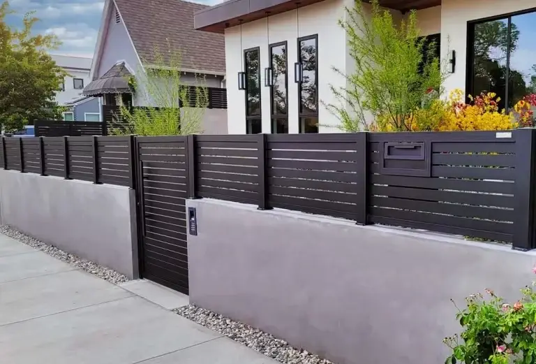 Close-up of an aluminum privacy fence panel showing the powder-coated wood-grain finish that holds colour and gloss for decades