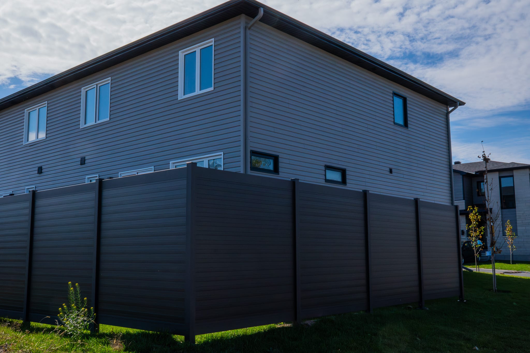Black aluminum privacy fencing installed around a multi-unit residential complex
