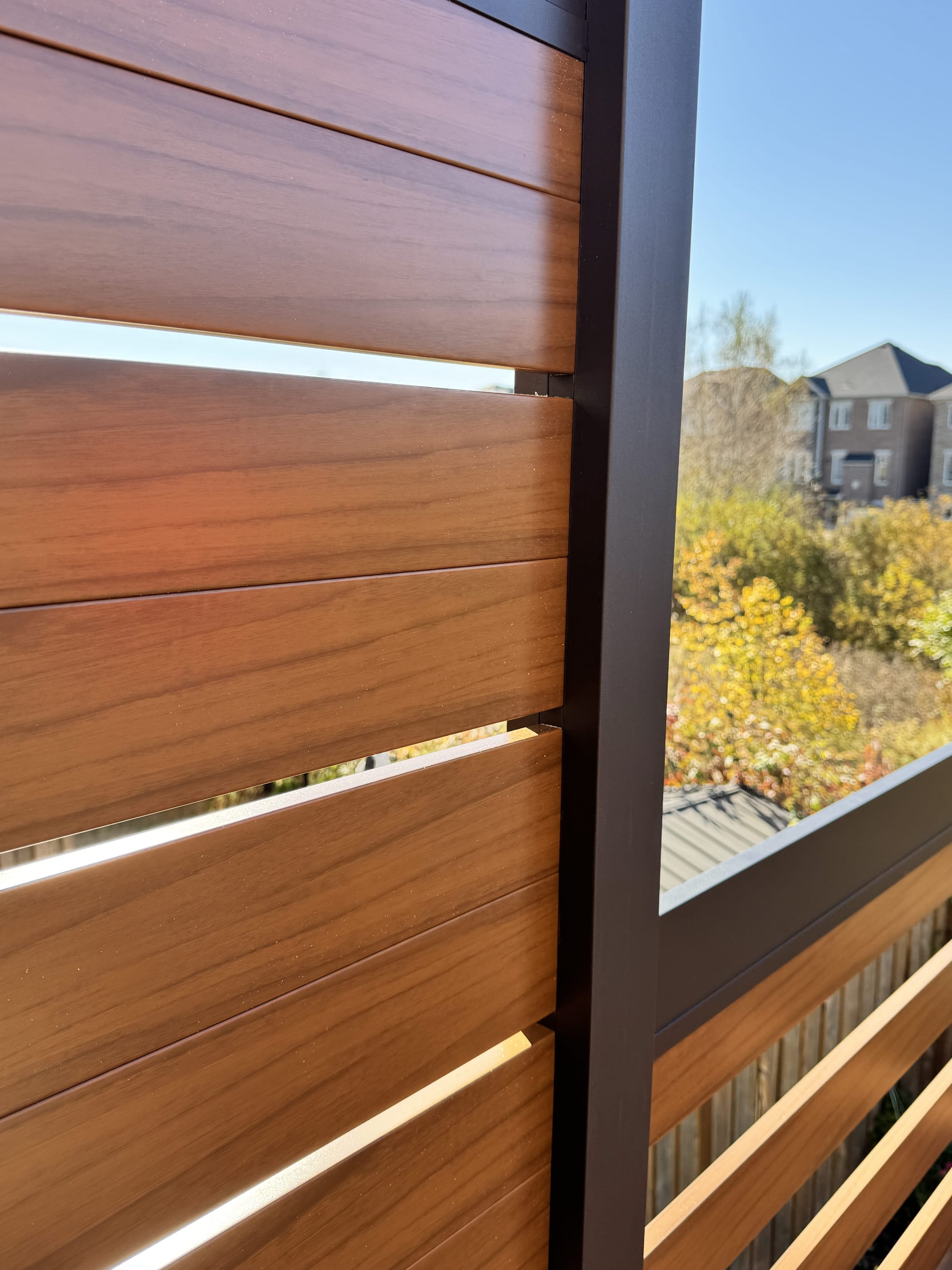 Aluminum privacy fence professionally installed along a deck in a Canadian backyard